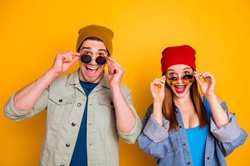 Photo of two nice glad positive stunned people taking off eyewear isolated yellow summer background