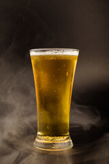 Beer glass with beer bubbles on a black background.