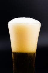 Beer glass with beer bubbles on a black background.