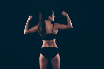 Rear back behind view portrait of her she nice attractive content sportive strong lady showing perfect shape form figure arm wrestler isolated over black background