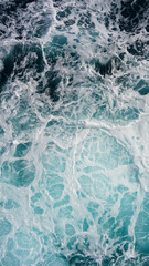 Fototapeta na wymiar seething water. texture of blue foamy sea water. clear ocean water background. sun reflection
