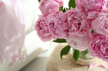 Bouquet of beautiful peonies on pouf indoors, closeup