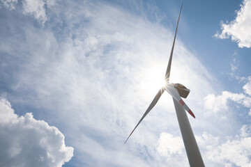 Modern wind turbine against cloudy sky, low angle view. Alternative energy source