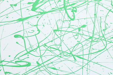 Green paint splashes on white canvas as background. Art and creativity