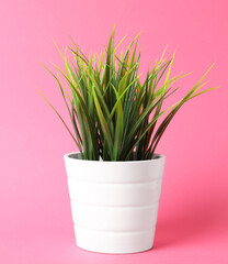 Beautiful artificial plant in flower pot on pink background, space for text
