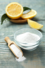 Baking soda and cut lemon on blue wooden table
