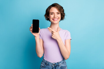 Portrait of positive cheerful girl hold smartphone point index finger indicate modern technology...