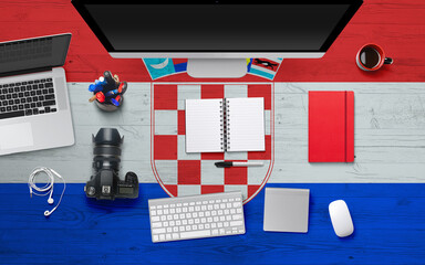 Croatia flag background with headphone,camera, notebook and mouse on national office desk table.Top view with copy space.Flat Lay.