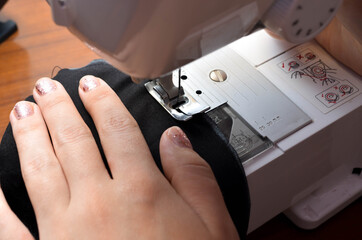 Making a medical black mask with your own hands at home. DIY protective mask. Black mask on a white background. Cotton mask