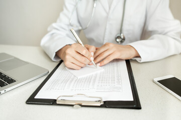  the doctor makes notes in the patient card. High quality photo