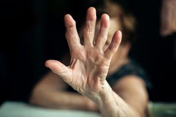 The old woman shuts her hand against the camera.