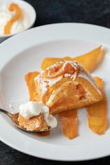 Portion of homemade carrot sponge roll with sour cream mousse and carrot jam on a white plate decorating with sliced carrot in sugar syrup