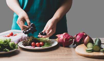 Woman preparing fresh fruits and vegetables for cooking salad, Healthy vegan food