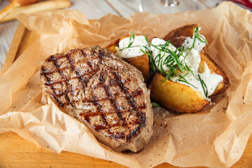 Beef steak with baked potatoes with sour cream