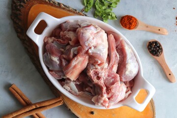 Fresh raw goat meat or mutton or lamb pieces. Preparation for Indian mutton curry. Spice at the background such as cinnamon sticks, red chili powder, black pepper & coriander. Copy space.