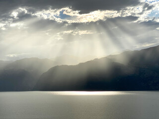 sunrays shine through cloud holes on the water surfaces and reflect