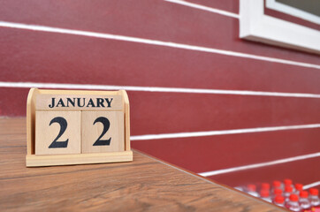 January 22, Number cube with wooden table beside the wall.