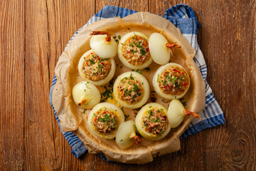 Onion baked with cheese stuffed with minced meat. Top view.  Served in parchment.