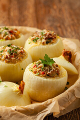 Onion baked with cheese stuffed with minced meat. Front view.  Served in parchment.