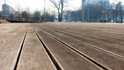 Fototapeta na wymiar Close perspective of wooden decking floor, blurry background