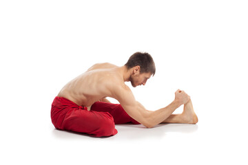 Fototapeta na wymiar Caucasian adult man doing yoga exercises in studio at white background 