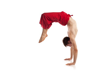 Caucasian adult man doing yoga exercises in studio at white background 