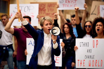 Displeased businesswoman shouting through megaphone on public demonstrations.