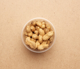 Inshell peanuts in a transparent plastic bowl