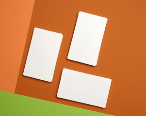 piles of white paper blank business cards on orange-green background