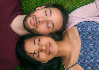 Interracial couple liying on the grass