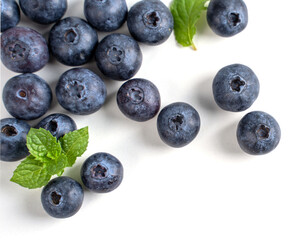 Blueberry fruit top view isolated on a white background, flat lay overhead layout with mint leaf, healthy design concept.
