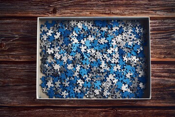 Closeup shot of small blue and grey puzzle pieces in the box