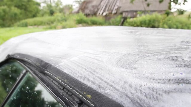 cleaning and washing the hinged top of the cabriolet roof with a cleaning agent with foam.