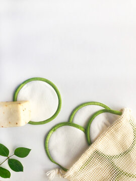 Cosm&eacute;tica belleza natural, ecol&oacute;gica, vegana y reutilizable. Algodones org&aacute;nicos, esponja y pastilla de jab&oacute;n para limpieza facial y corporal. Fondo blanco y madera.