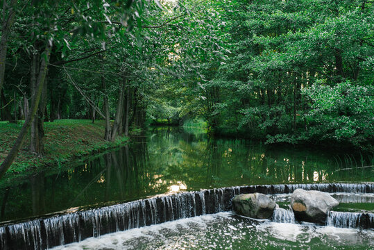 Beautiful cascading mini waterfall on the river in the forest Park "Drozdy" in Minsk
