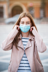 Young woman wearing medical face mask to protect herself from pollution, germs and coronavirus