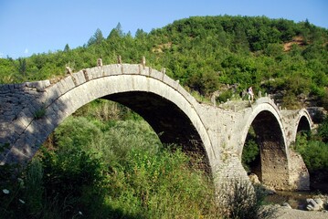 Fototapeta na wymiar The traditional three-arched stone-made bridge Kalogeriko at Kipoi village, one of the 45 villages known as Zagoria or Zagorochoria in Epirus region of southwestern Greece, August 9 2010.