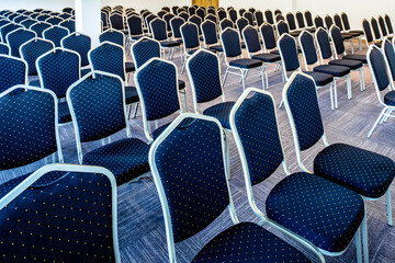 Convention hall with seats in a row with no people.
