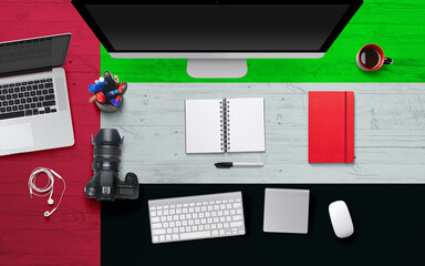Fototapeta na wymiar United Arab Emirates flag background with headphone,camera, notebook and mouse on national office desk table.Top view with copy space.Flat Lay.
