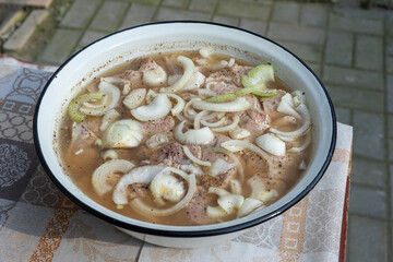the kebab is marinated in a large pelvis with onions