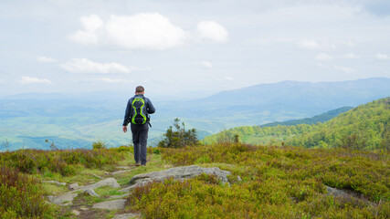Obraz premium a guy with a backpack walks in the mountains. Ukrainian mountains. Active recreation in the local mountains.