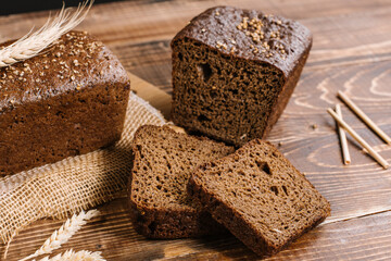Fresh crunchy bread loafs and pieces on the wooden background