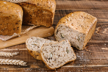 Fresh crunchy bread loafs and pieces on the wooden background