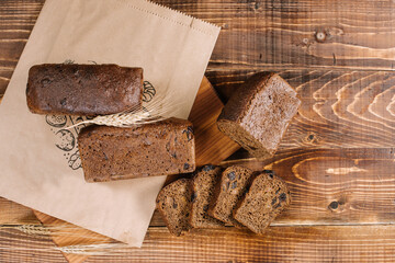 Fresh crunchy bread loafs and pieces on the wooden background