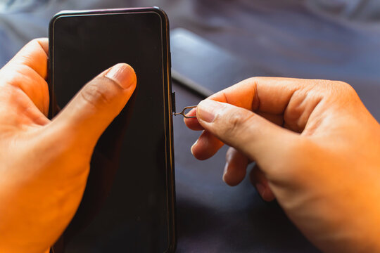Employees are changing the phone SIM card, nano SIM card in the shop for customers to buy, Man's hand.