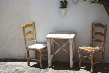 White rustic table and chairs on an outdoor terrace