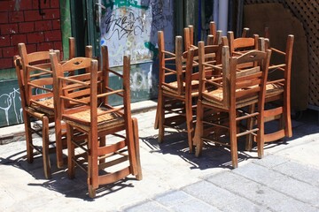 Greece, Athens, June 28 2020 - Chairs stacked outside of a traditional restaurant in the touristic district of Monastiraki.