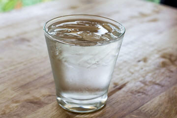 water with ice cubes on wooden table