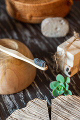 Natural handmade soaps, bamboo toothbrush other natural elements on a wooden table.