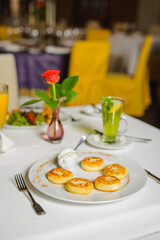 Cheese pancakes or syrniki on the table. Social distancing. Breakfast in empty restaurant.